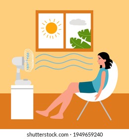 Woman sitting in her house in front of an electric fan. She exhausted of hot summer day. Sweaty and thirsty.