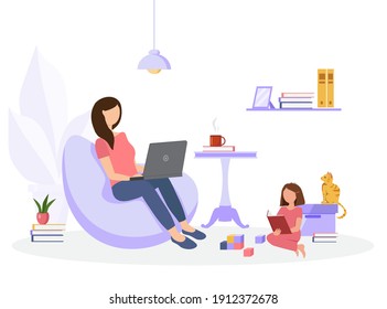 A woman is sitting on a beanbag chair in her home and working on a laptop. Her daughter plays and reads nearby. Work from home concept.