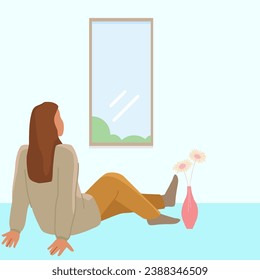 woman sitting on the floor near the window