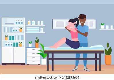 woman sitting on massage table african american masseur doing healing treatment massaging injured patient manual physical therapy rehabilitation concept hospital office interior horizontal