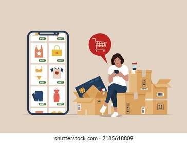 Woman sitting on the package, Shopping online using mobile phone. Customer selects the goods to online shopping . Girl with smartphone and credit card. 