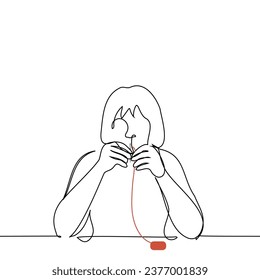 woman sitting at the table threads the eye of a needle - one line art vector. concept of sewing by hand or embroidering