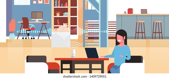 woman sitting at workplace with laptop using intelligent smart speaker with voice recognition artificial intelligence assistance concept modern workspace office interior flat horizontal portrait