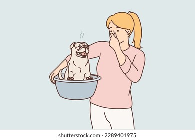 Woman smells unpleasant smell emanating from dog wanting to swim to wash off stench after walk. Girl housewife with pug dog in basin takes care of pet, going to wash puppy from dirt 