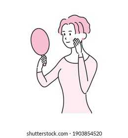 
A woman smiling while looking at a hand mirror