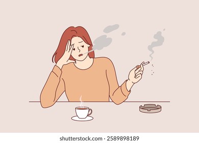 Woman smokes cigarette and drinks hot coffee from cup, sitting at table taking break after difficult work. Stressed girl suffering from tobacco addiction and habit of caffeine for energy.