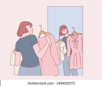 A woman standing in front of a mirror in a clothing store and picking clothes. hand drawn style vector design illustrations. 