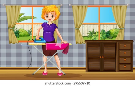 Woman standing and ironing a shirt in a room with garden view behind