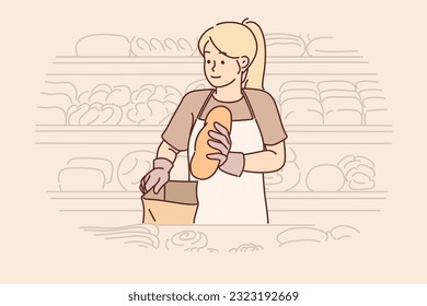 Woman stands in bakery putting bread in paper bag and working as sales assistant to help choose delicious product. Girl seller from bakery dressed in apron, near racks with freshly baked baguettes