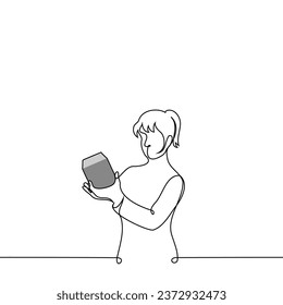 woman stands holding a box in her hand and reads it or examines it in detail - one line art vector. concept receiving a gift, buying small equipment