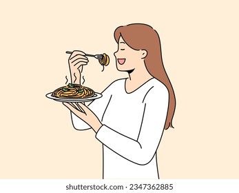 Woman stands with plate of spaghetti in hands and eats italian dish enjoying taste of pasta. Girl eats pasta to satisfy hunger and rejoice at opportunity to try delicious high-calorie food