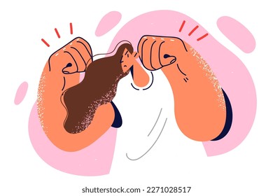 Woman stands in pose boxer, clenching fists to show self-confidence and ability to fight. Girl boxer with negative expression on face, without gloves on fists wants to fight to defend opinion