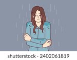 Woman stands shivering in rain without outer clothing and risks getting sick and catching cold due to sudden onset of autumn. Girl was caught in rain and quickly got wet because of lack of umbrella