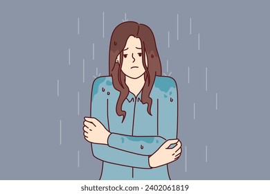 Woman stands shivering in rain without outer clothing and risks getting sick and catching cold due to sudden onset of autumn. Girl was caught in rain and quickly got wet because of lack of umbrella