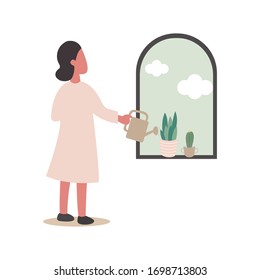 The woman stood, watering the flowers and cactus on the window and looking out the window to see the sky. The concept of life was confined to home during the coronary virus COVID-19 outbreak.