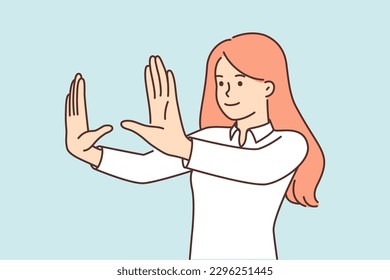 Woman stretches arms forward, making frame of palms when choosing place to place picture or position furniture in interior. Red-haired girl focuses to make choice for successful photo or video