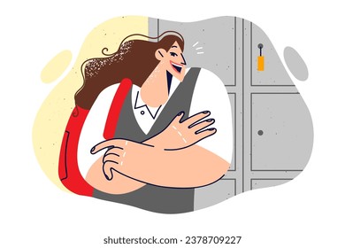 Woman student with backpack stands in university building near lockers for storing personal belongings and textbooks. Girl student posing with arms crossed, rejoicing in getting education in college