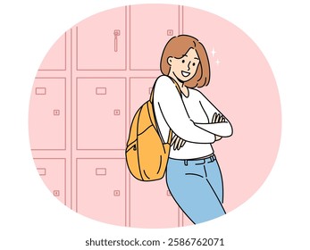 Woman student stands near boxes for personal items in college hallway and looks at screen smiling. Girl student at university or high school rejoices at opportunity to receive quality education.