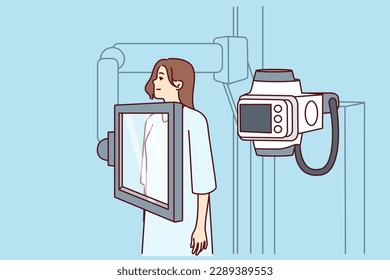 Woman suffering from cancer stands near x-ray machine making medical examination for diagnosing oncological disease. Girl during mammogram for early detection of breast cancer undergoes radiography