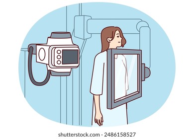 Woman suffering from cancer stands near x-ray machine making medical examination for diagnosing oncological disease. Girl during mammogram for early detection of breast cancer undergoes radiography