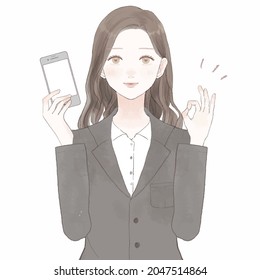 A woman in a suit holding a smartphone and holding an ok sign. On white background.