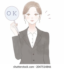 Woman in suit with OK sign. On white background.