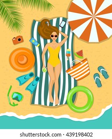 Woman sunbathing on a beach under the tropical palms with  accessories for beach as umbrella, flip flops, striped beach towel, hat, flippers, paddles, snorkeling mask, float, bag, icecream, watermelon