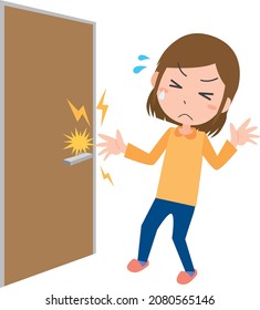 A Woman Surprised By The Stimulus Of Static Electricity Trying To Touch The Doorknob