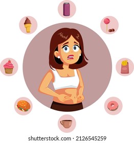 Woman Surrounded by Fast Food Holding Her Belly Fat. Unhappy young person storing abdominal fat from unhealthy eating habits
