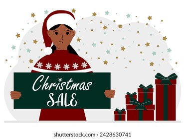 A woman in a sweater and a red Santa hat holds a poster with the text about Christmas sale in his hand.