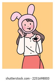 A woman taking a selfie with a camera switch in her hand. cute rabbit mask.