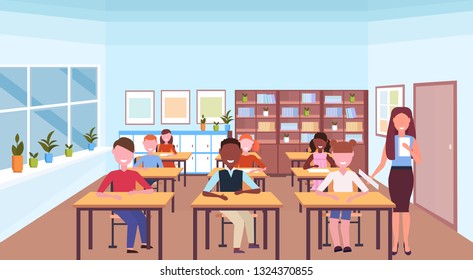 woman teacher reading book during lesson mix race pupils sitting desks education concept modern school classroom interior horizontal flat