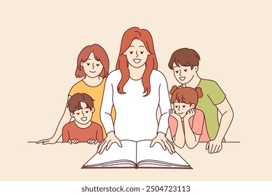 Woman teacher shows interesting book to happy children and smiles, rejoicing, giving kids knowledge. Children book for primary education and development of curiosity among elementary school students