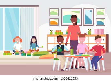 woman teacher teaching mix race boys and girls preschool modern kindergarten children classroom with desk chairs playground kid room interior full length flat horizontal