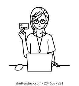 a woman teacher using laptop computer at her desk and holding a credit card