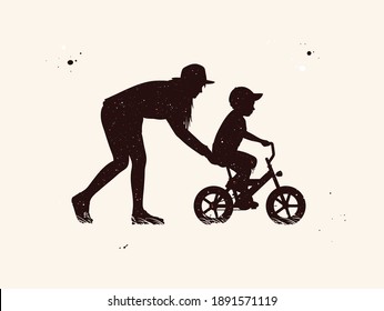 Woman teaching boy to ride bicycle. Mother and child silhouettes