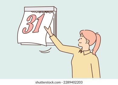 Woman tears off sheet of calendar with number 31 at end of month and beginning of new period. Time management and calendar monitoring concept for schedule abidance and meeting deadlines