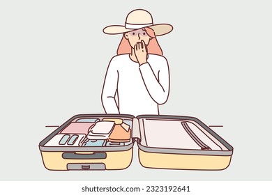 Woman tourist with travel suitcase is worried about losing personal belongings or stealing money from bag. Girl tourist in hat feels despair after learning about loss of gadgets from luggage