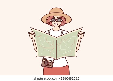 Woman tourist uses paper map to navigate and find popular attractions or directions to hotel. Young girl tourist in hat and sunglasses travels around world exploring new cities and countries