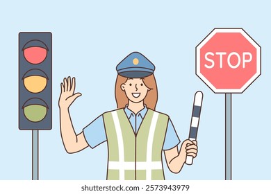 Woman traffic inspector regulates movement of cars, standing near traffic light and stop sign. Smiling girl road inspector waves striped stick to avoid congestion automobiles at intersection