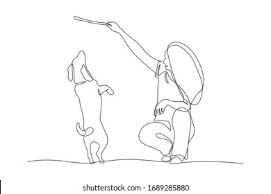 Woman training dog with stick in continuous line art drawing style. Owner playing with her cute dog on a walk. Black linear sketch isolated on white background. Vector illustration