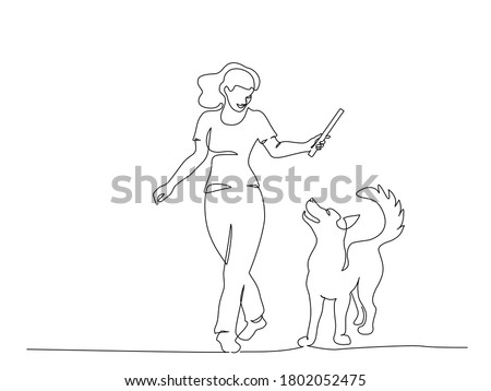 Woman training dog with stick. Continuous one line art drawing style. Owner playing with cute dog on walk. Black linear sketch isolated on white background. Vector illustration