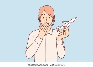 Woman travel agent holds airplane and covers mouth with hand, feeling shocked by information about plane crash. Girl agent of travel company is nervous after learning about cancellation of air service