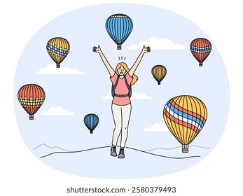 Woman traveler stands among rising balloons and joyfully raises hands up enjoying travel to delightful festival. Concept of travel and getting positive emotions from tours to exotic places