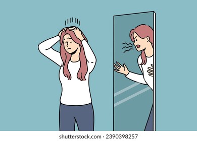 Woman is trying to restrain aggression, standing near mirror with angry reflection, for concept of mental disorder. Girl with mental problems or split personality needs help of psychotherapist