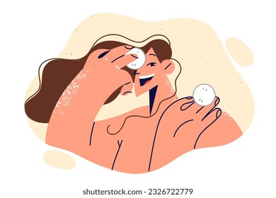 Woman uses cotton pads to treat face and fight wrinkles or remove excess makeup before bed. Happy girl recommends purchasing cotton pads to help cleanse or moisturize skin without going to beautician.