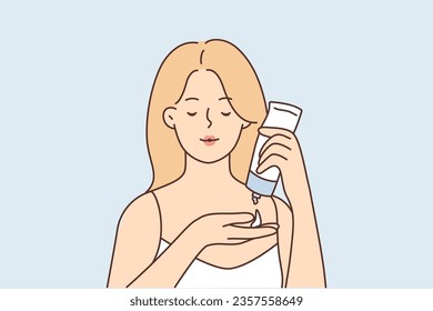 Woman uses facial moisturizer cream and holds tube, squeezing anti-aging lotion into palm. Beautiful girl demonstrates sunscreen or cosmetic cream to protect skin from harmful effects of sunlight