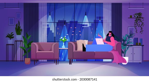 woman using laptop in dark night living room social media network online communication concept