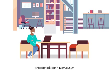 woman using laptop listening to music with headphones african american businesswoman sitting workplace creative office co-working center interior horizontal full length