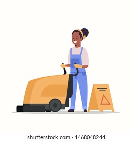 woman using professional washing machine african american female cleaner janitor in uniform near wet floor sign cleaning service concept flat full length